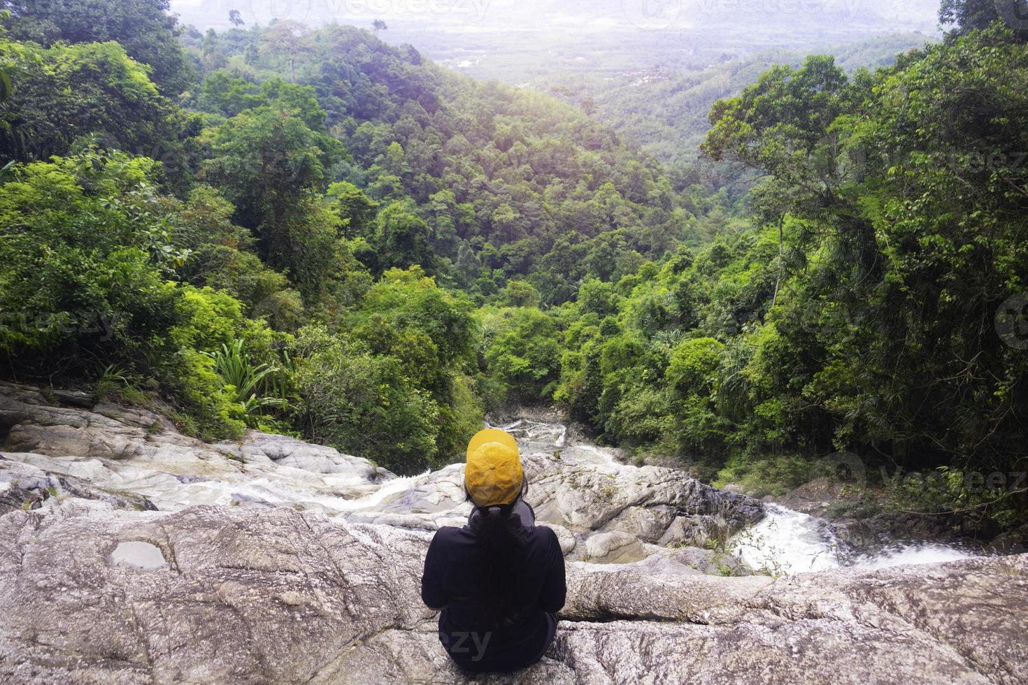 femme assise dans la cascade.jeune détente dans la cascade.bon concept sain, paisible.photo voyage et style de vie. photo