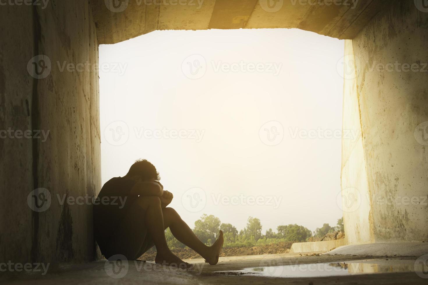 asie vous homme assis seul.il est assis sous un grand tunnel.homme très triste et déprimé.triste,seul,suicide.désespoir. maladie.photo concept de santé et de déception. photo