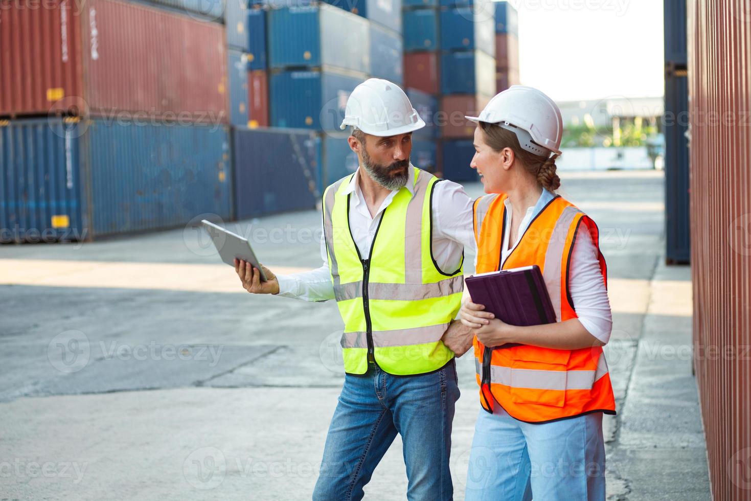 les responsables masculins et féminins discutent et vérifient leur travail pour l'expédition au client. distribution stockage commerce port fret. photo