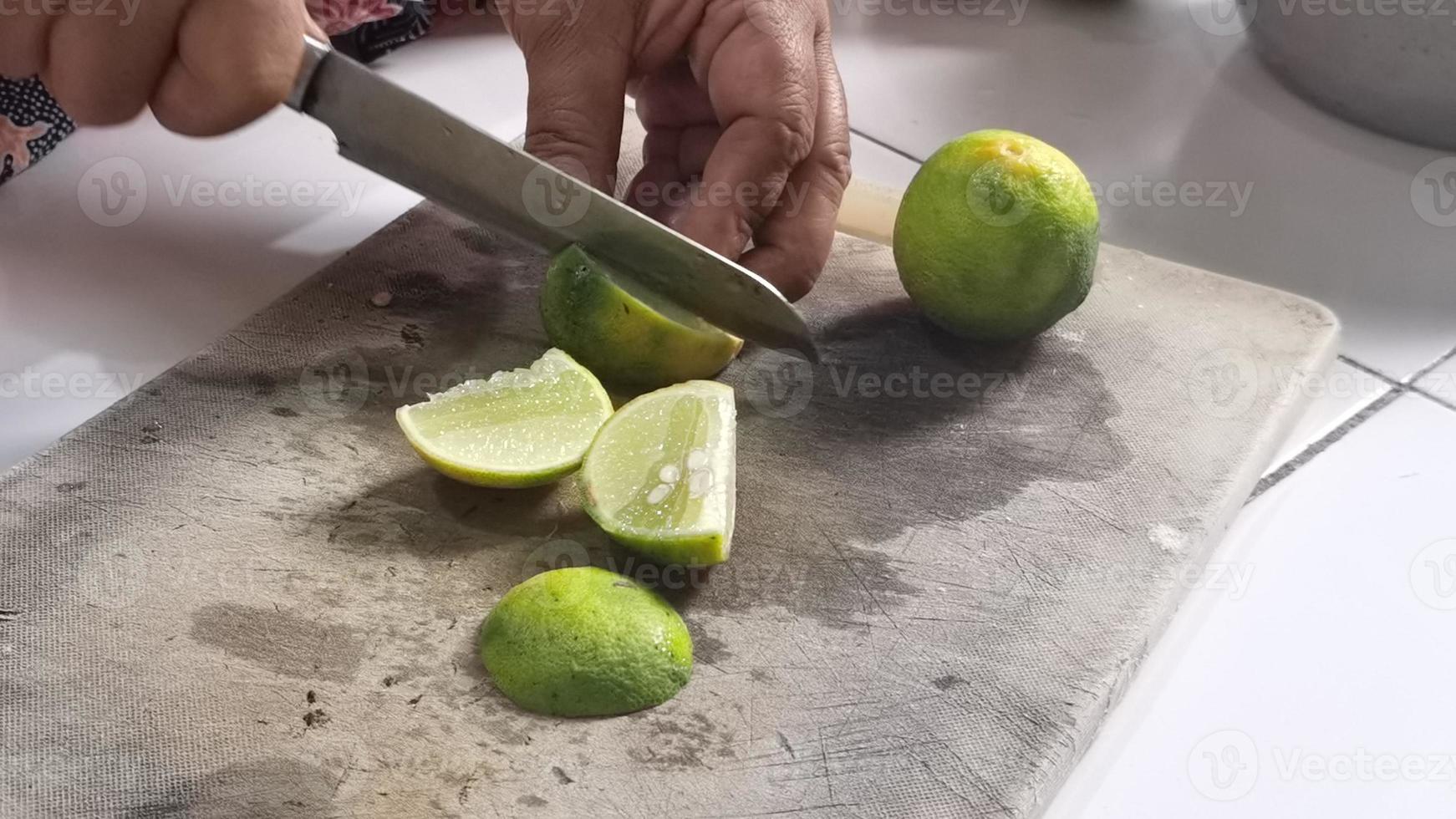 gros plan couper la chaux sur une planche à découper dans la cuisine photo