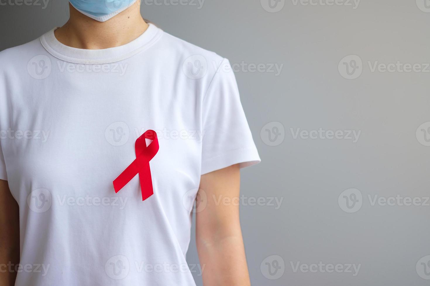 main tenant un ruban rouge pour la journée mondiale du sida de décembre, le  mois de