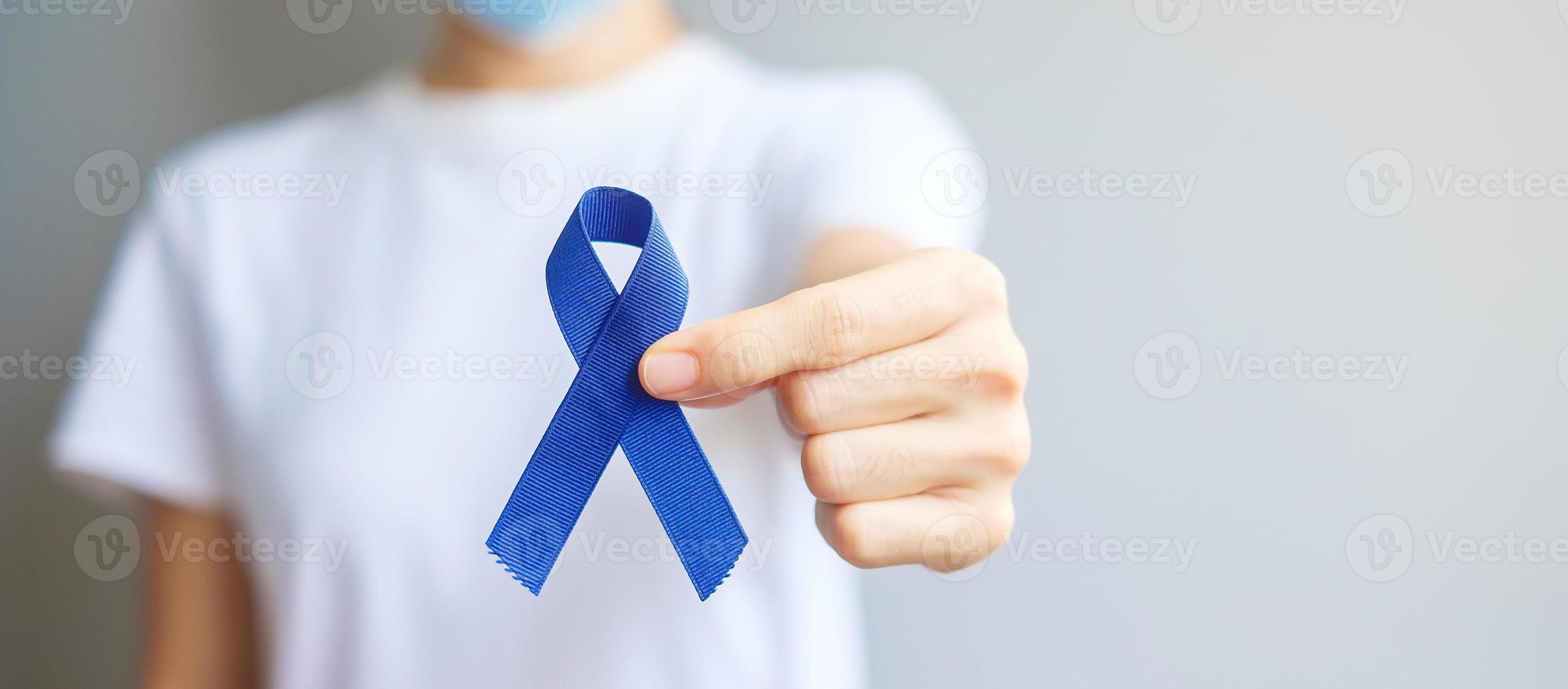 mars mois de sensibilisation au cancer colorectal, femme tenant un ruban bleu foncé pour soutenir les personnes vivant et malades. soins de santé, espoir et concept de la journée mondiale du cancer photo