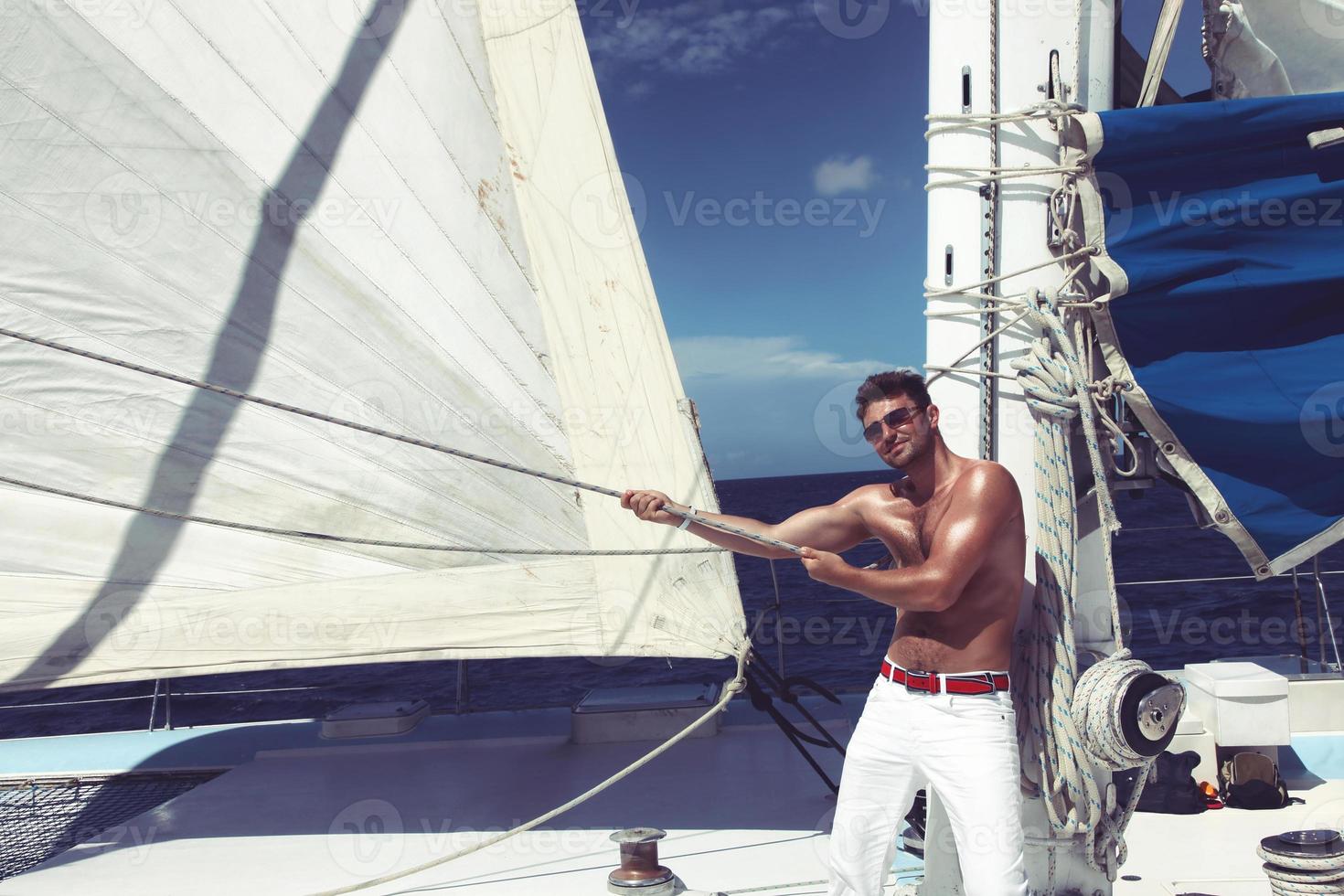 jeune homme naviguant sur son bateau en pleine mer photo