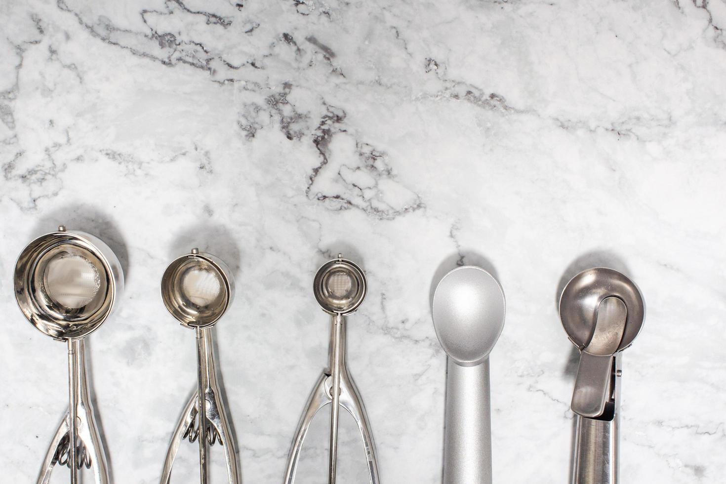 le corps de haft de boules de glace vides sur une table en marbre de différentes tailles, quantités et matériaux montre le concept de cuisine. photo