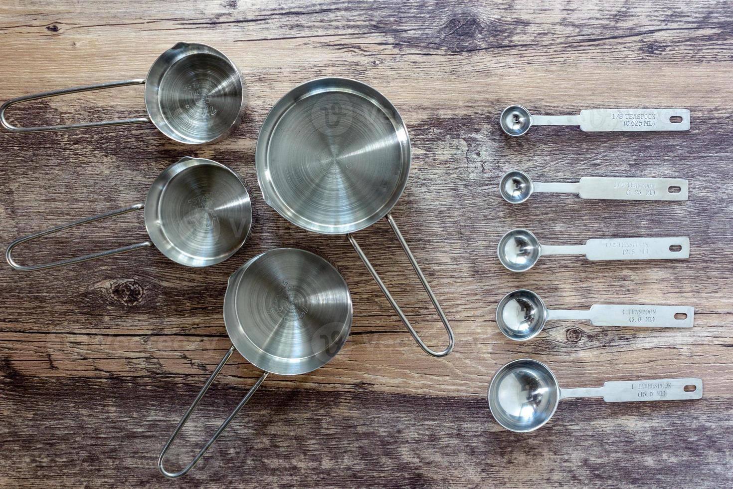 ensemble de tasses à mesurer et cuillère à mesurer avec une poignée en acier inoxydable sur une table en bois en vue de dessus photo