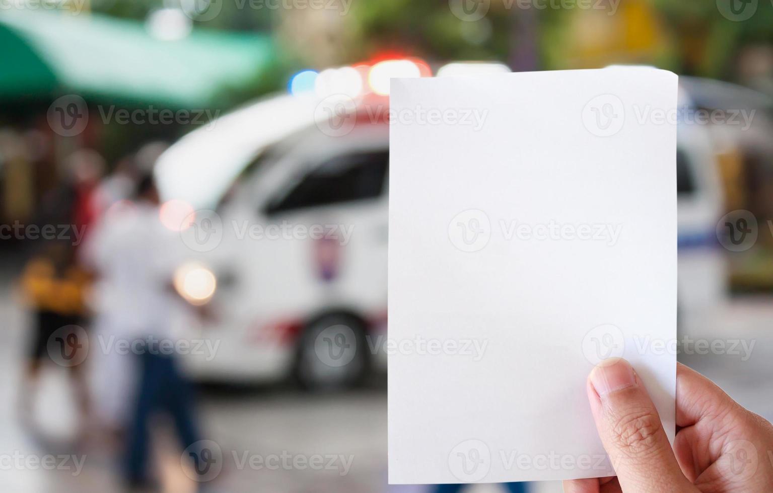 main tenir un livre blanc avec une ambulance répondant à un appel d'urgence photo