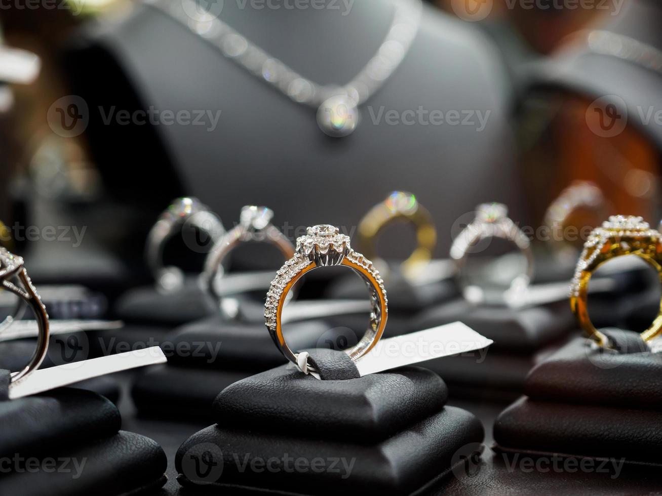 bagues et colliers de diamants de bijoux montrent dans l'affichage de vitrine de magasin de détail de luxe photo