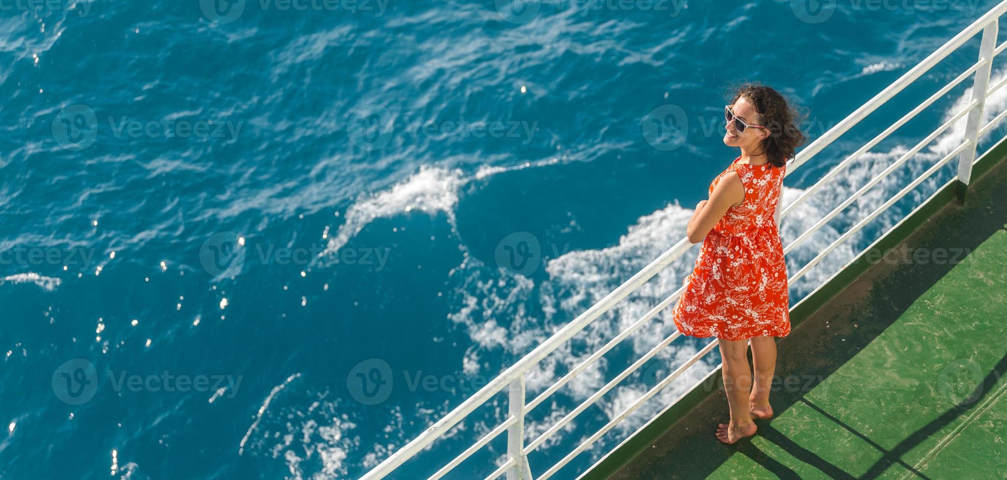 une femme navigue sur un bateau de croisière et regarde l'eau photo