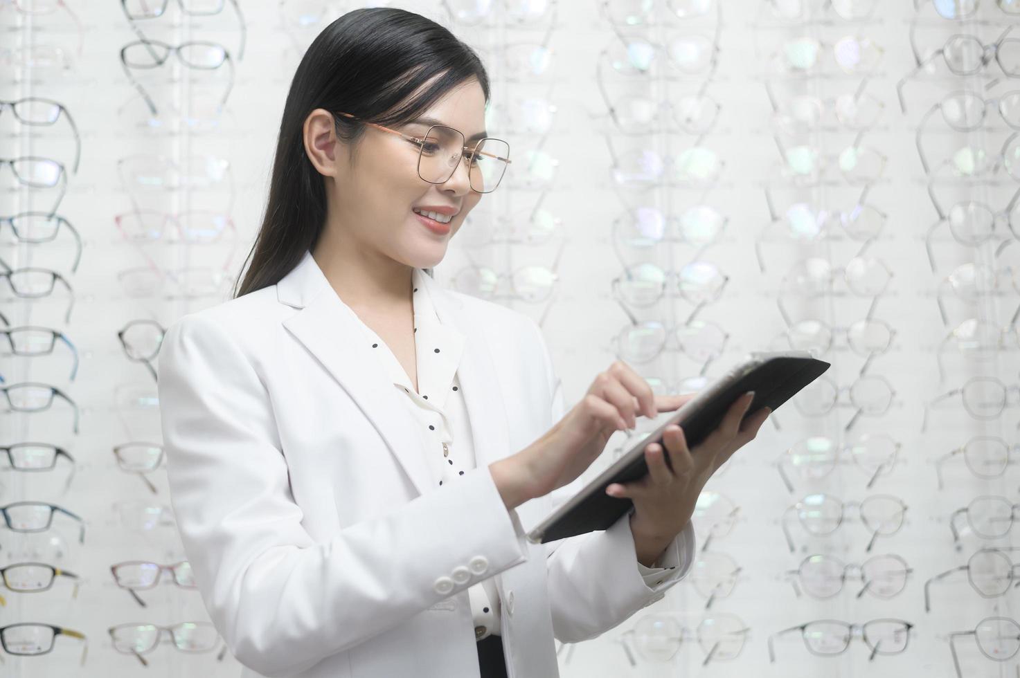 jeune ophtalmologiste tenant une tablette dans un centre optique, concept de soins oculaires. photo