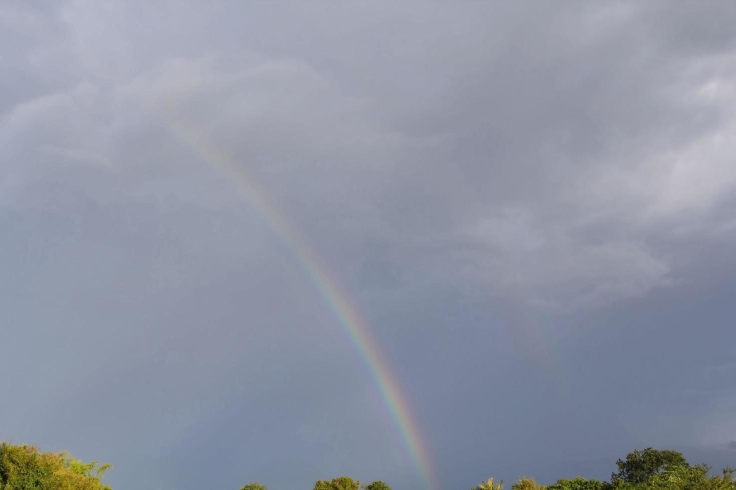 les arcs-en-ciel se produisent généralement après de fortes pluies et des tempêtes. pendant la saison des pluies, le ciel est généralement clair et beau, mais le soleil est très chaud. photo