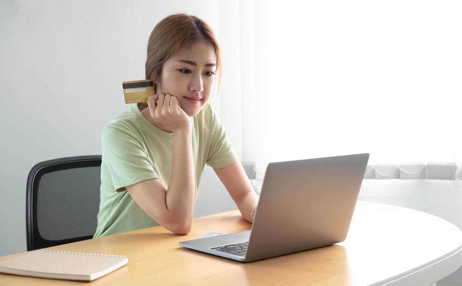 paiement en ligne woman's hands holding a credit card and using laptop computer for online shopping photo