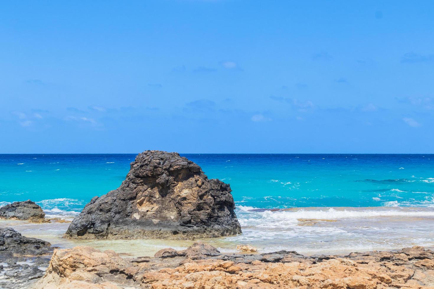 gros rocher noir sur la plage photo