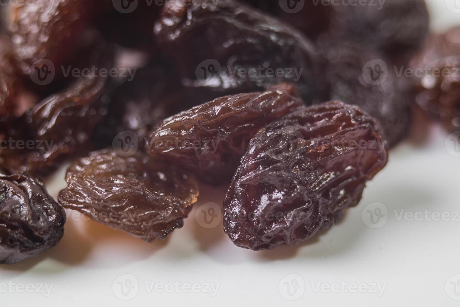 Raisins secs noirs sur fond blanc photo