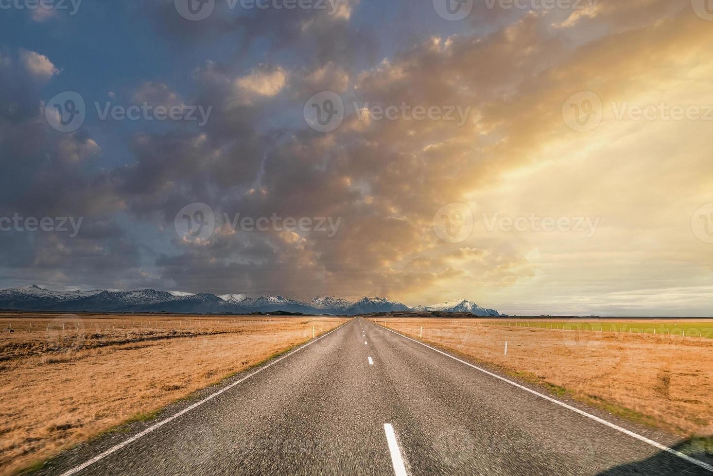 Route décroissante vide au milieu d'un paysage volcanique contre le ciel au coucher du soleil photo