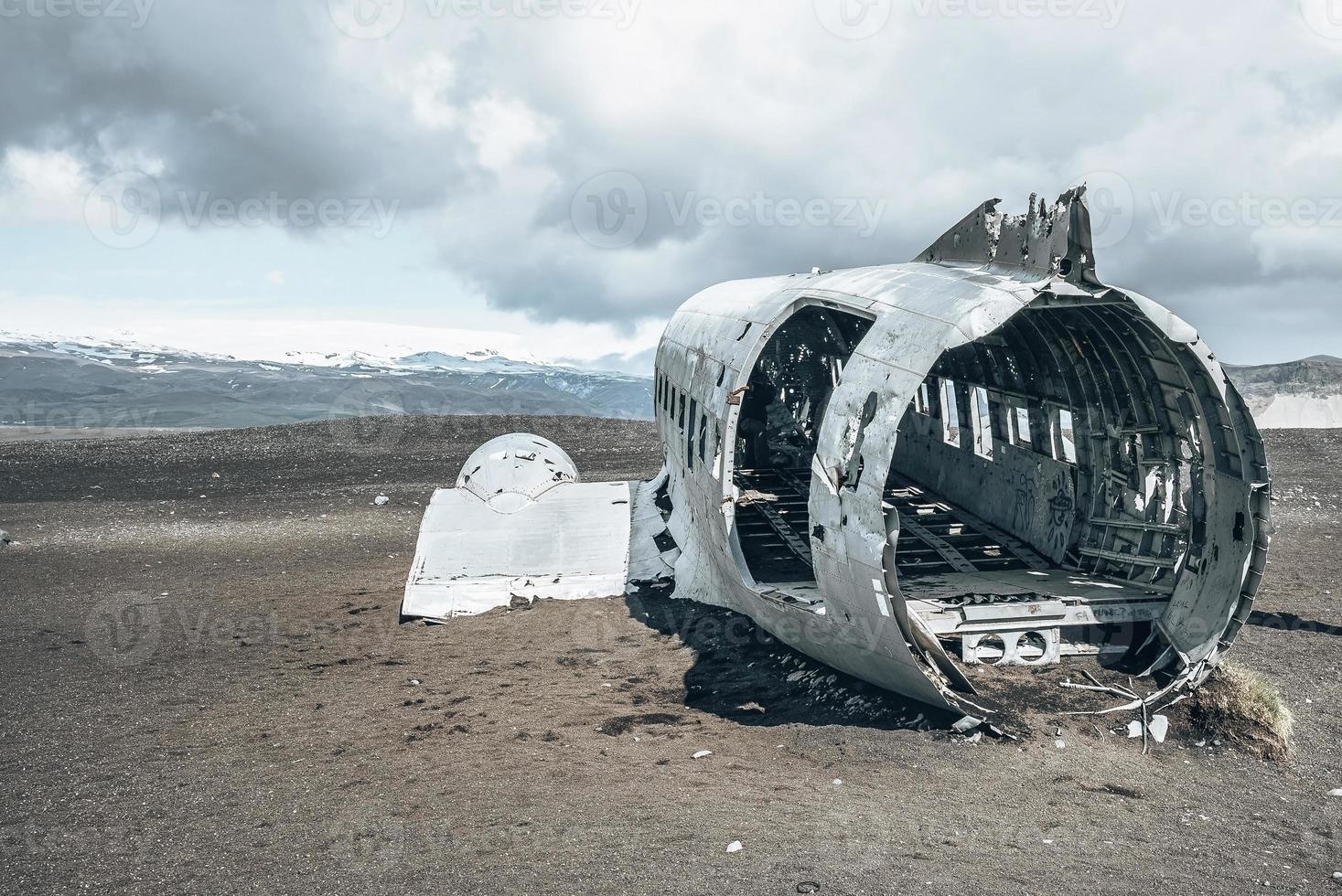 Épave d'un avion militaire cassé à la plage de sable noir à solheimasandur contre le ciel photo