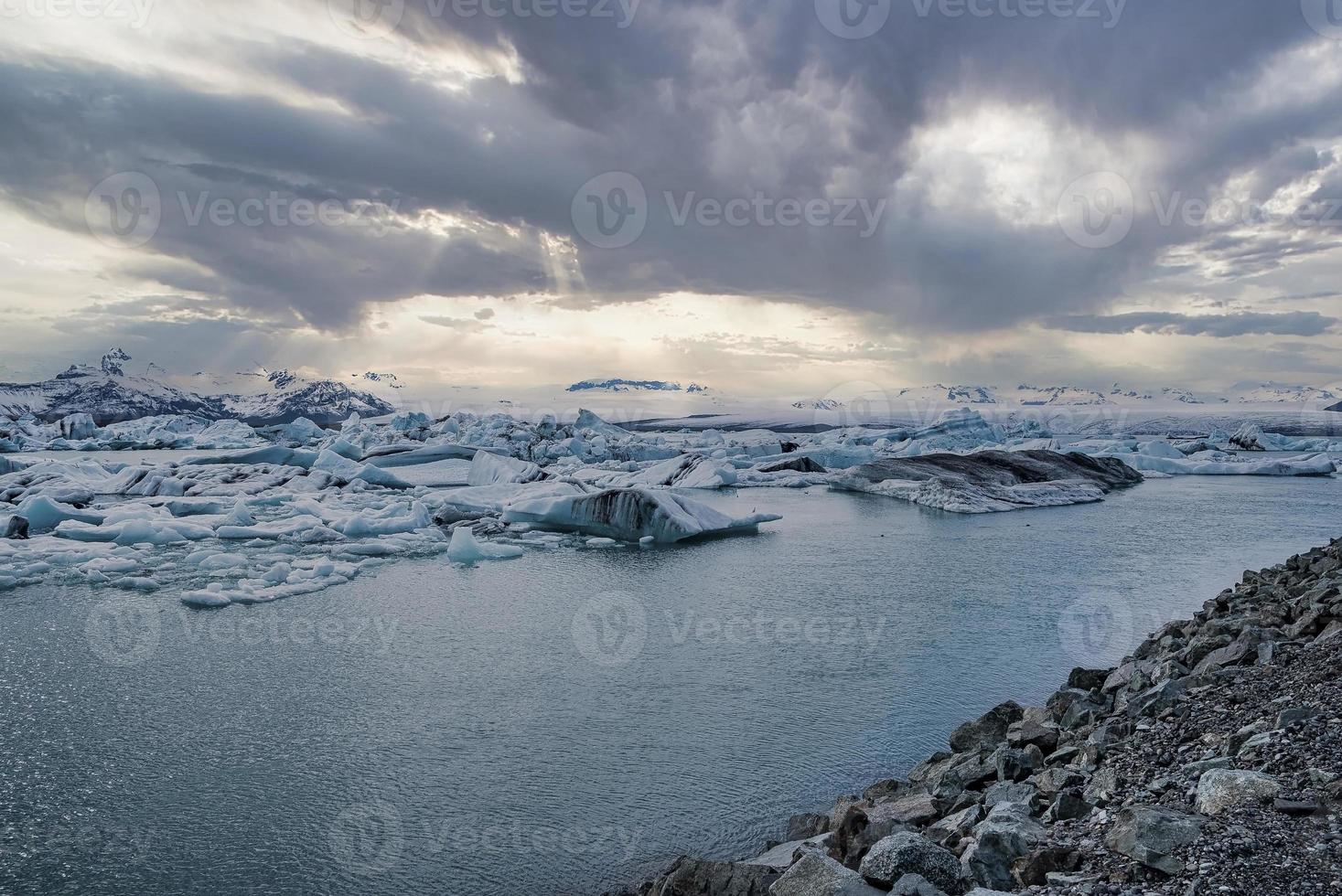 lagune glaciaire idyllique de jokulsarlon contre un ciel dramatique au coucher du soleil photo