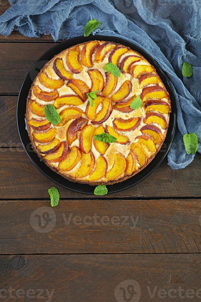 délicieuse tarte aux pêches maison sur fond de bois. vue de dessus photo