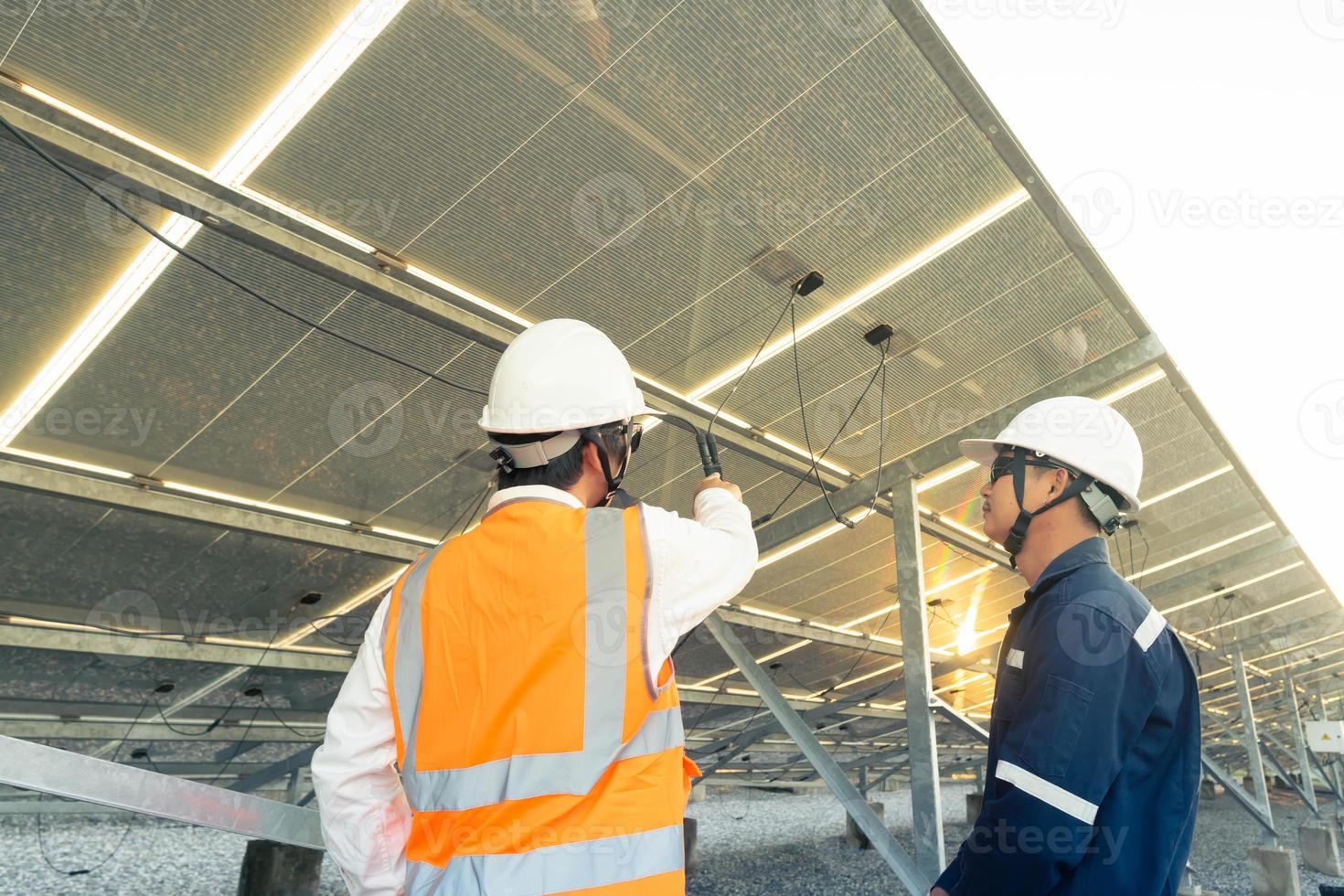 des ingénieurs avec un investisseur marchent pour vérifier le fonctionnement de la ferme solaire, des systèmes de panneaux solaires, de l'énergie alternative pour conserver le monde est de l'énergie, une idée de module photovoltaïque pour la production d'énergie propre photo