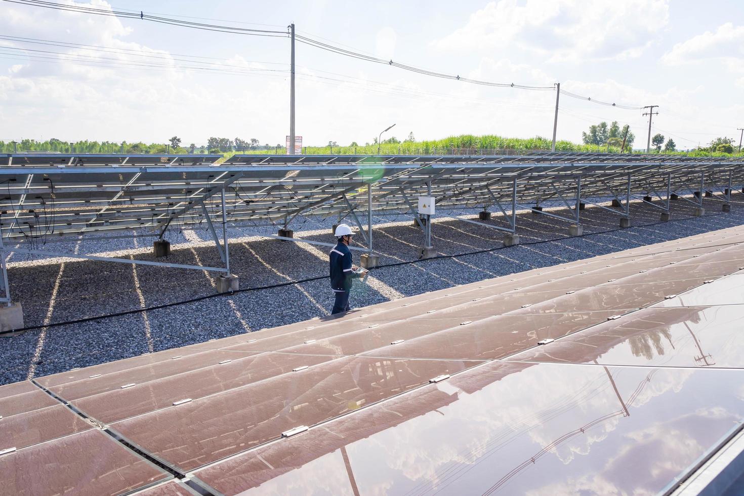 la ferme solaire, panneau solaire avec des ingénieurs à pied pour vérifier le fonctionnement du système, énergie alternative pour conserver l'énergie mondiale, idée de module photovoltaïque pour la production d'énergie propre photo