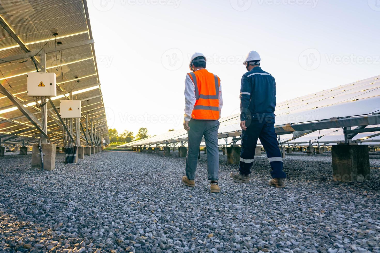 des ingénieurs avec un investisseur marchent pour vérifier le fonctionnement de la ferme solaire, des systèmes de panneaux solaires, de l'énergie alternative pour conserver le monde est de l'énergie, une idée de module photovoltaïque pour la production d'énergie propre photo