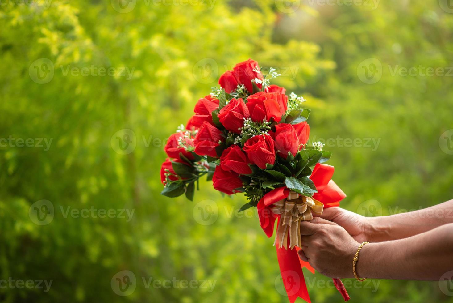 la main d'un homme donne une fleur rouge le jour de la saint valentin. photo