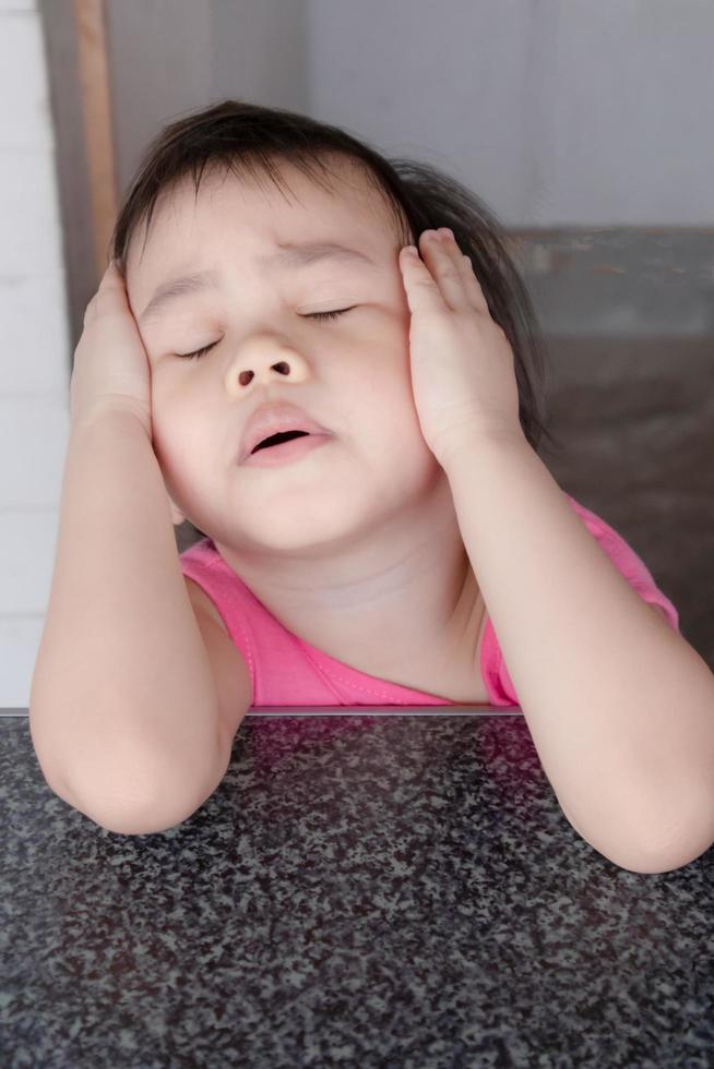 mécontenter une fille asiatique ferme les oreilles et les yeux a l'air agacé. photo