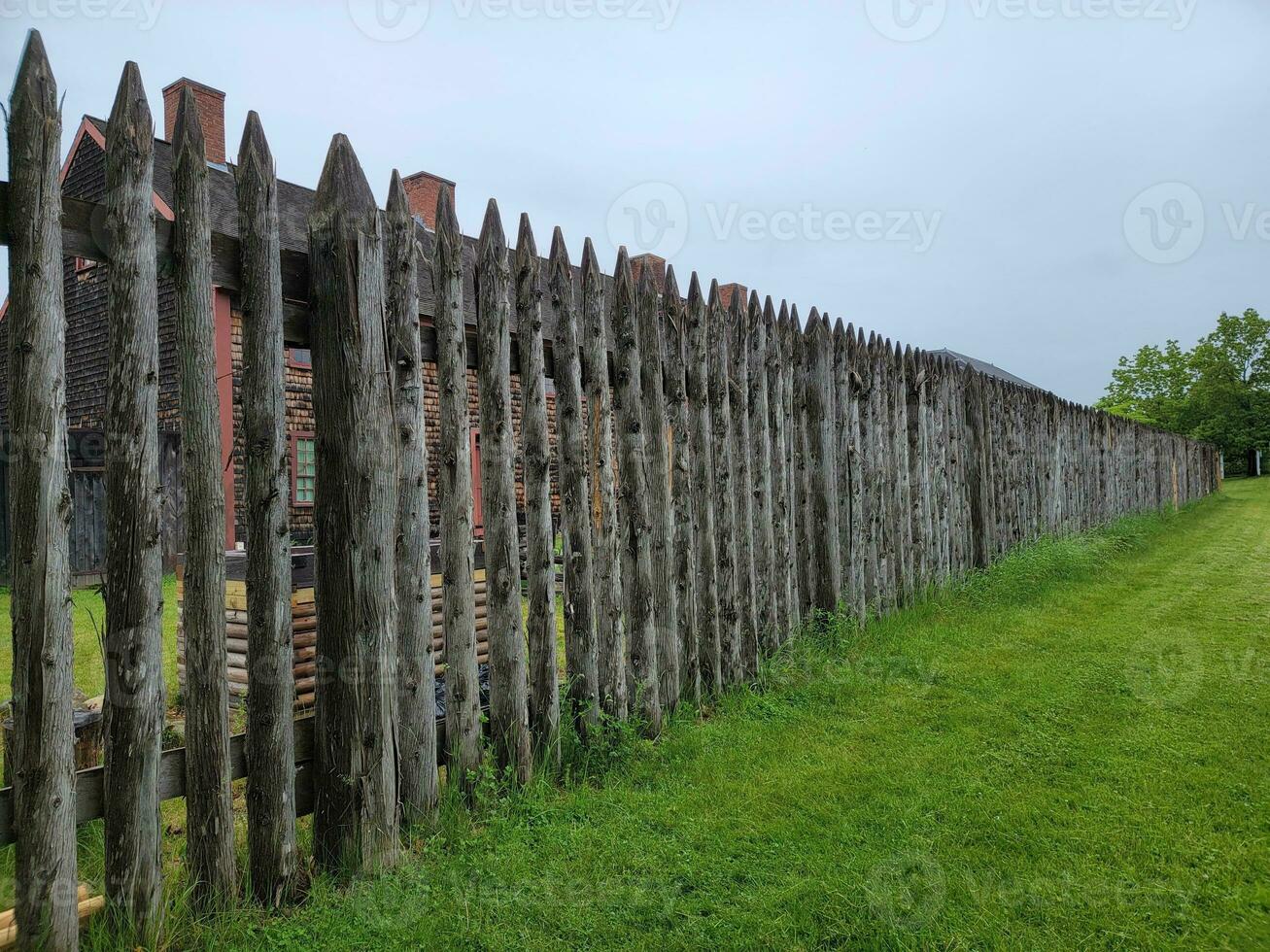 Clôture ou mur en bois pointu avec fort avec de l'herbe photo