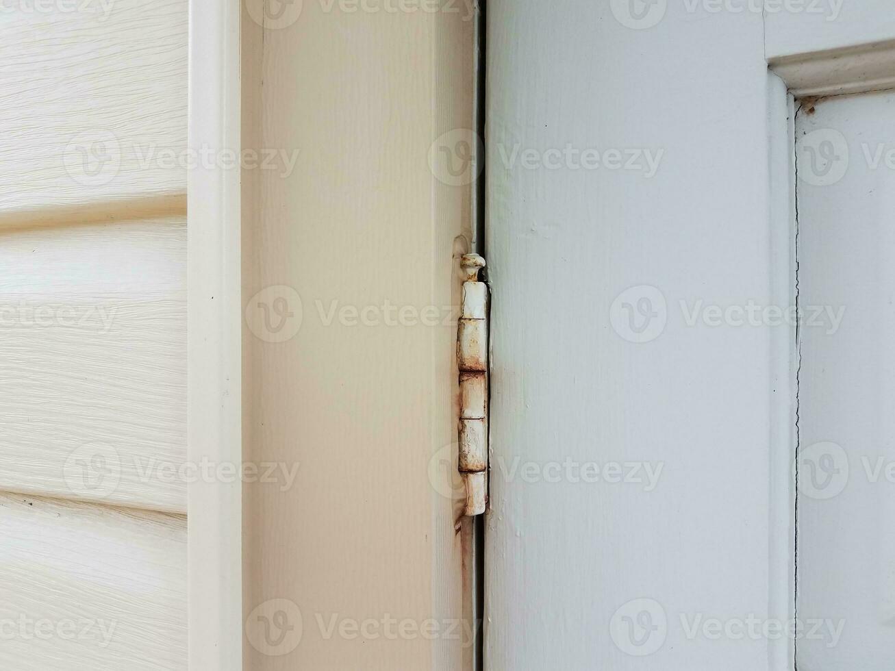 vieille charnière en métal avec de la rouille sur la porte blanche photo