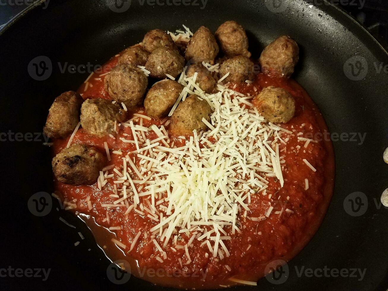 boulettes de boeuf à la sauce tomate dans une poêle avec du fromage photo