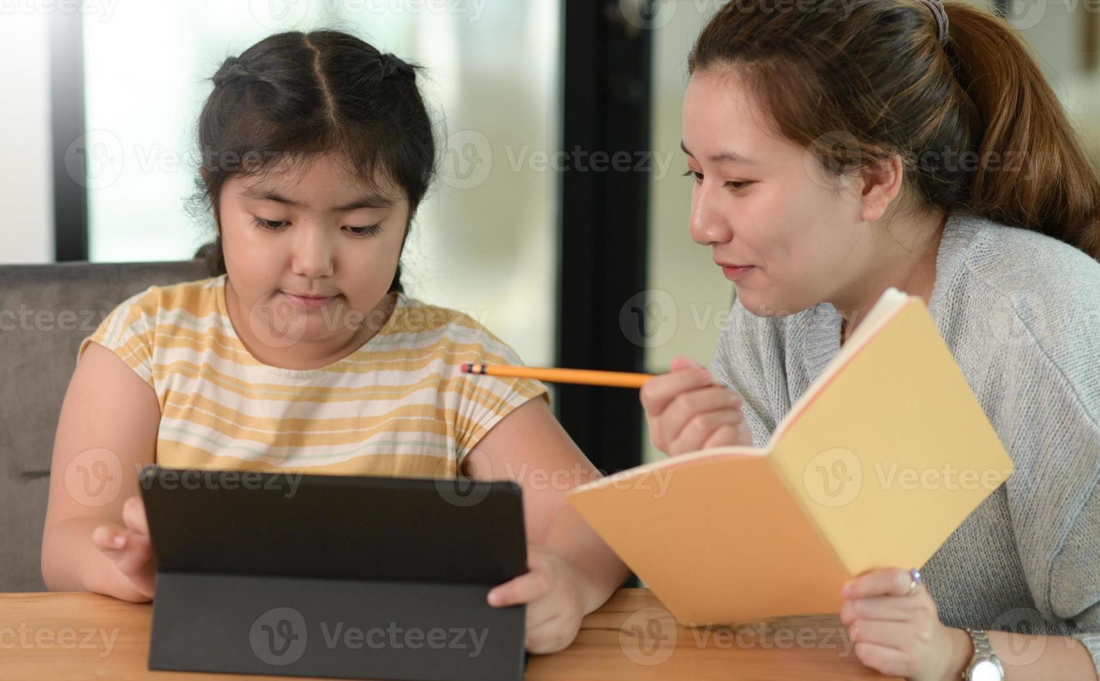 les filles asiatiques étudient avec un tuteur, des cours privés à la maison, des sœurs et des sœurs. photo