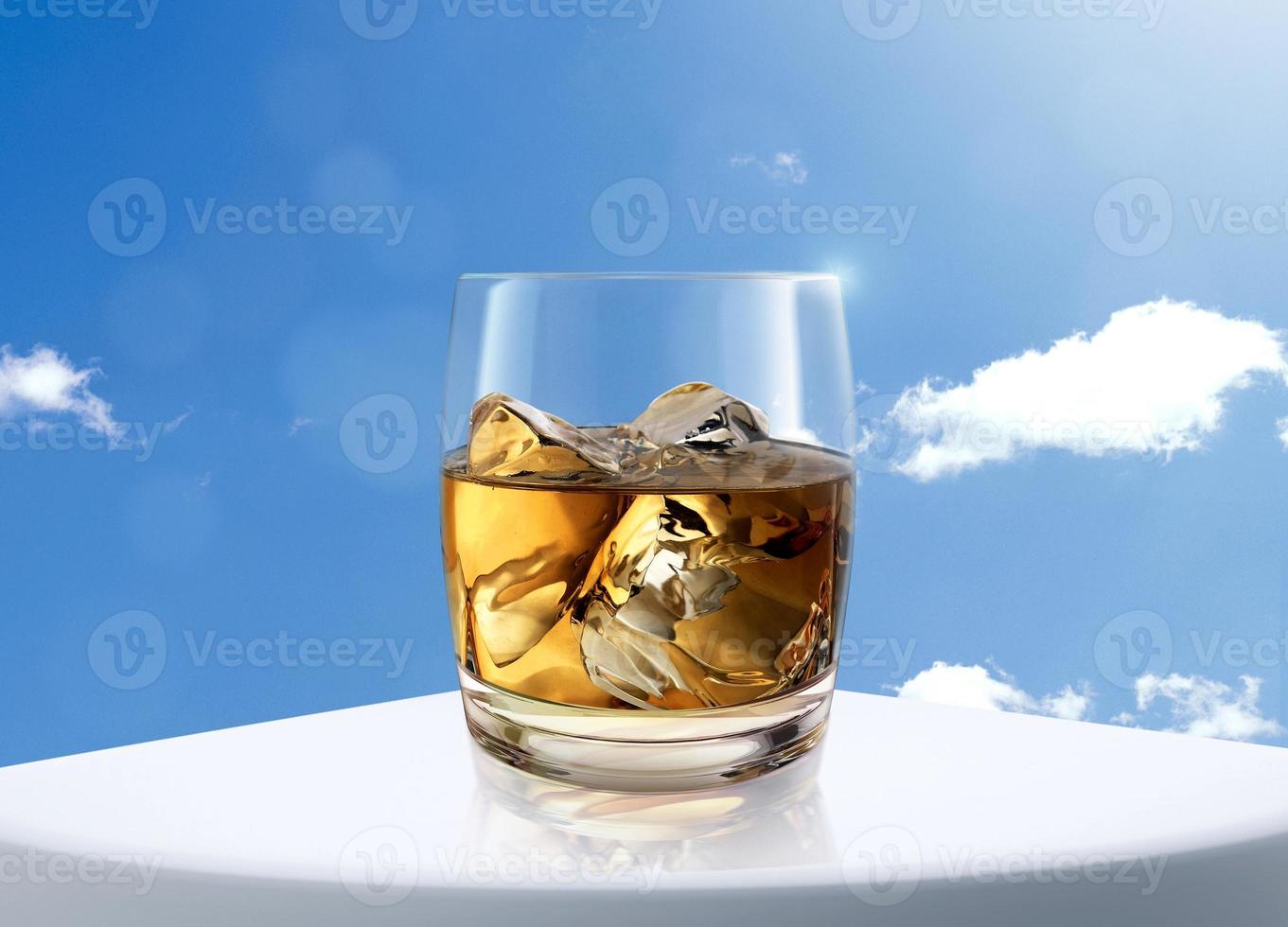 verre de whisky sur fond de table et ciel blanc photo