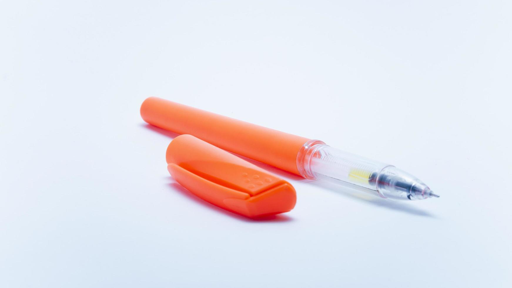 photo d'un stylo à bille orange vif sur fond blanc. convient aux éléments de conception de l'éducation, de la papeterie de bureau et des fournitures d'étude des étudiants.