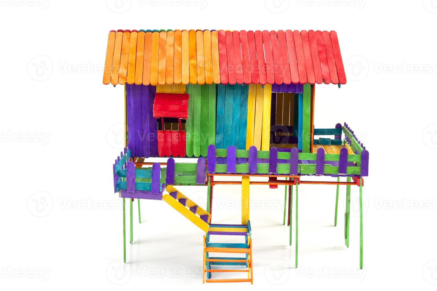 la maison de style thaïlandais est faite de jouets à partir de bâtons de popsicle colorés isolés sur fond blanc. photo