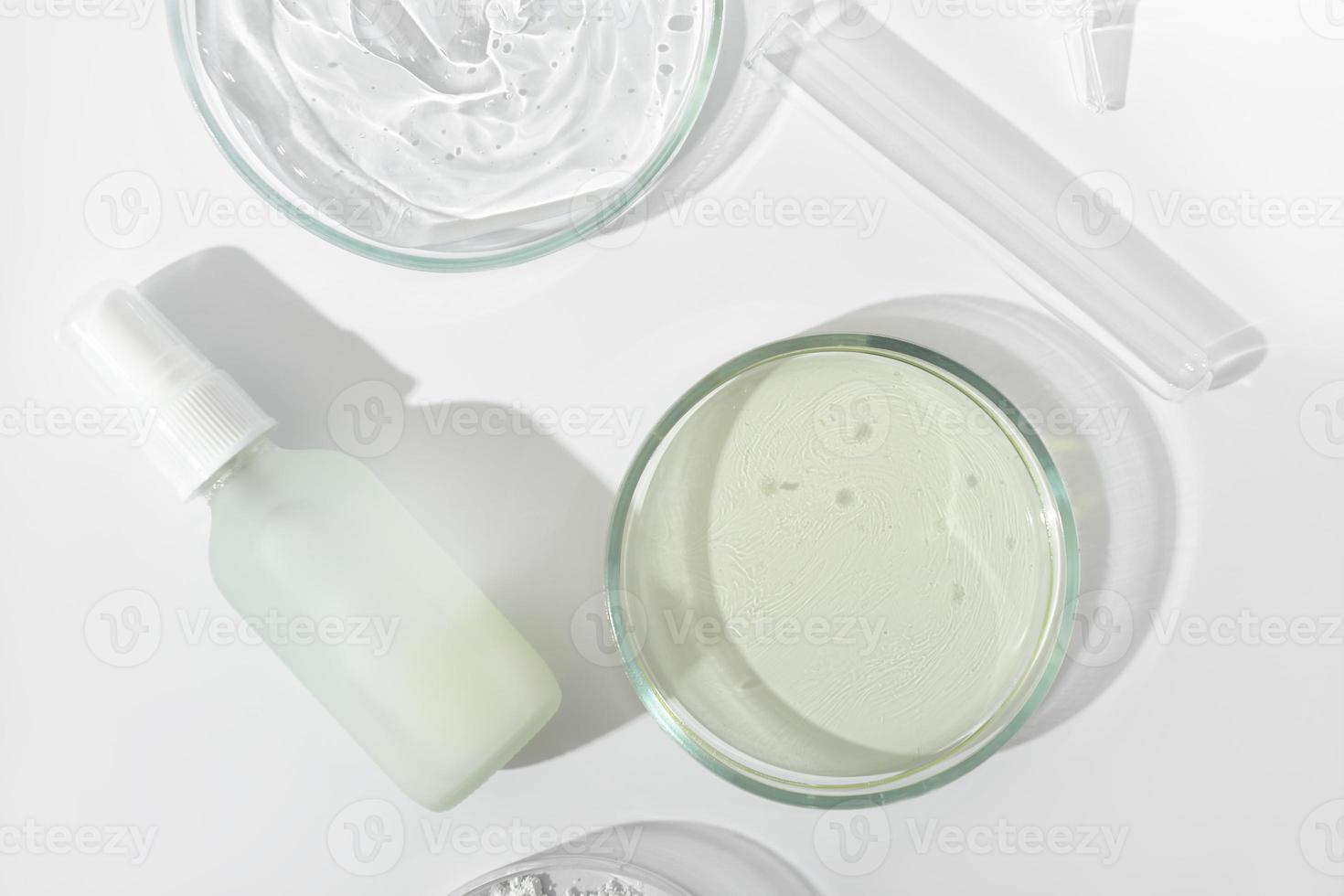 vue de dessus du liquide cosmétique dans une bouteille en verre et une boîte de Pétri et un tube à essai sur une table de laboratoire. recherche en laboratoire sur les ingrédients cosmétiques pour les soins de la peau et la sécurité des produits. photo