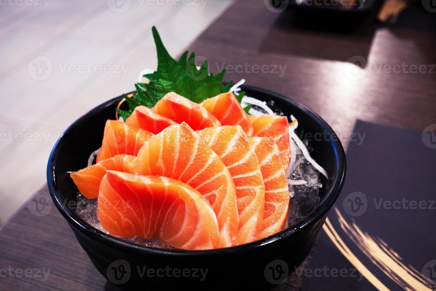 saumon sashimi sur la table du restaurant clair et sombre. photo