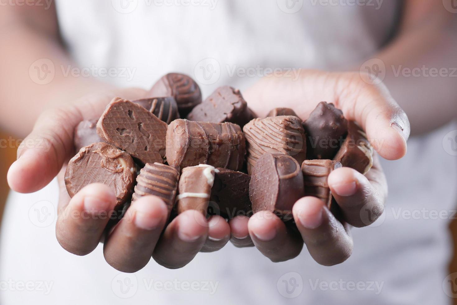 https://static.vecteezy.com/ti/photos-gratuite/p1/8260296-tenant-beaucoup-de-bonbons-au-chocolat-noir-gros-plan-photo.jpg