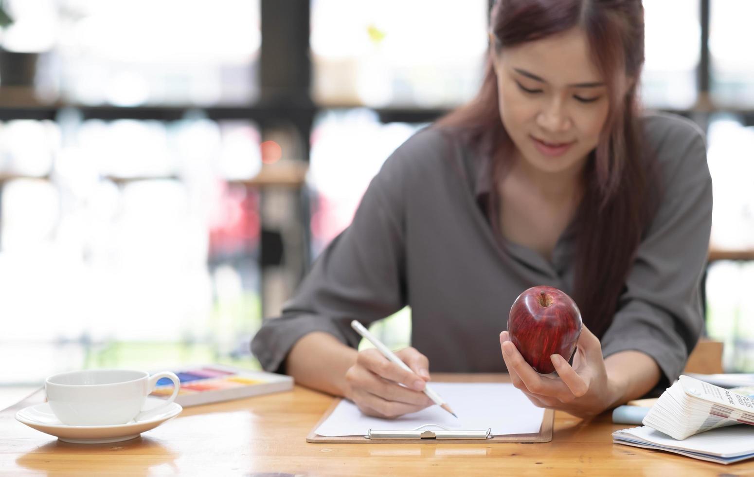 jeune graphiste asiatique dessinant une pomme sur son projet avec un lieu de travail créatif moderne photo