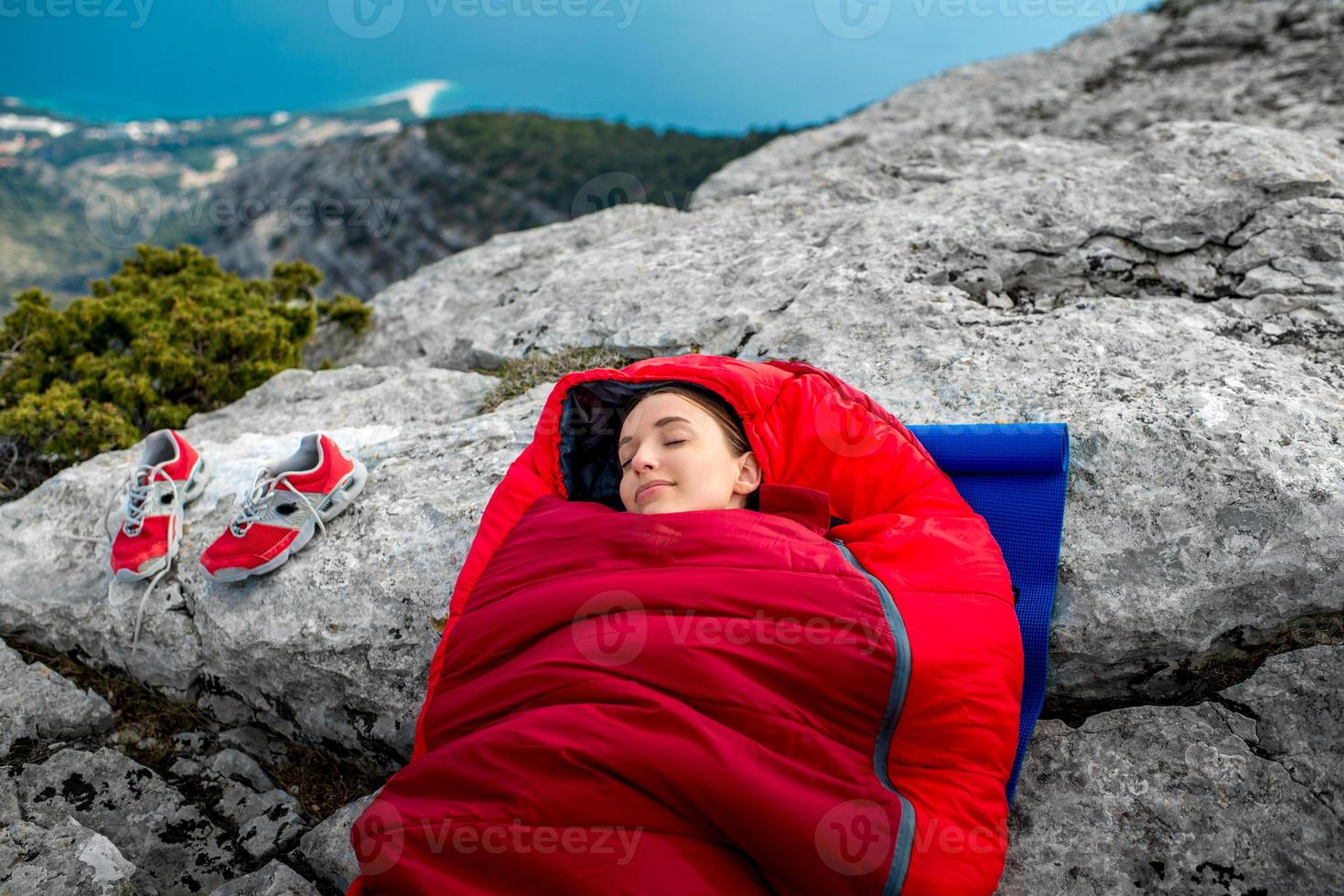 femme dans un sac de couchage sur la montagne photo