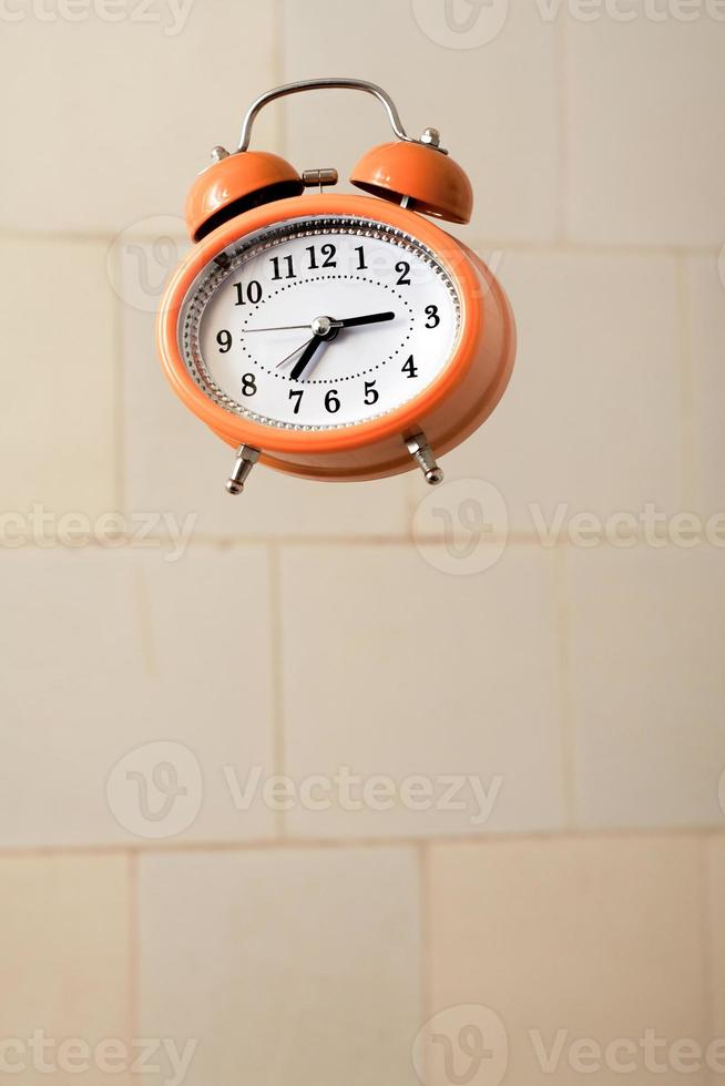 réveil de style vintage orange volant dans la salle de bain. photo
