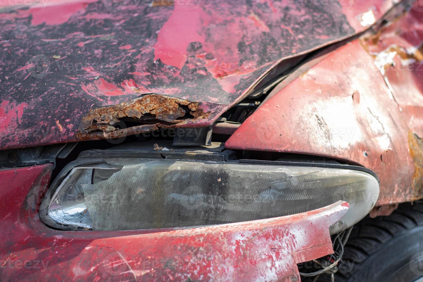 phares cassés à la suite d'une collision. voiture rouge cassée après un accident. notion d'accident de voiture. phare de secours, capot et pare-chocs endommagés. dommages à la carrosserie de la voiture après l'accident. photo