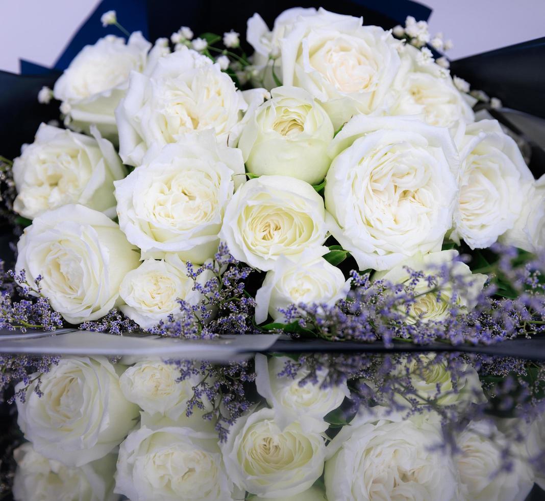 beau grand et un luxueux bouquet de roses blanches disposées en bouquet avec réflexion sur le sol photo