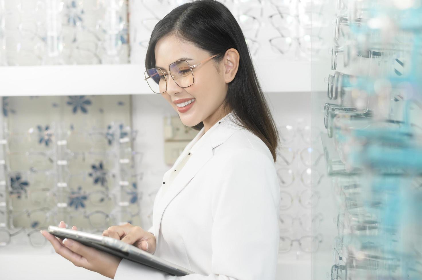 jeune ophtalmologiste tenant une tablette dans un centre optique, concept de soins oculaires. photo