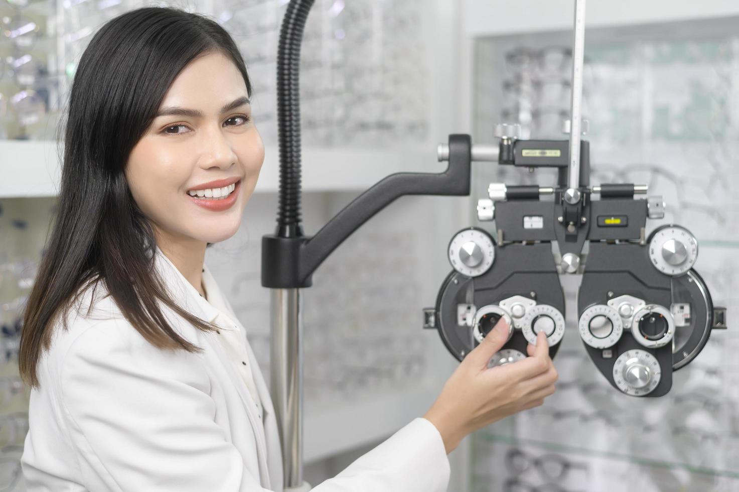 jeune ophtalmologiste faisant un test visuel pour le client à l'aide d'un appareil de mesure de la vue par optométrie bifocale dans un centre optique, concept de soins oculaires. photo