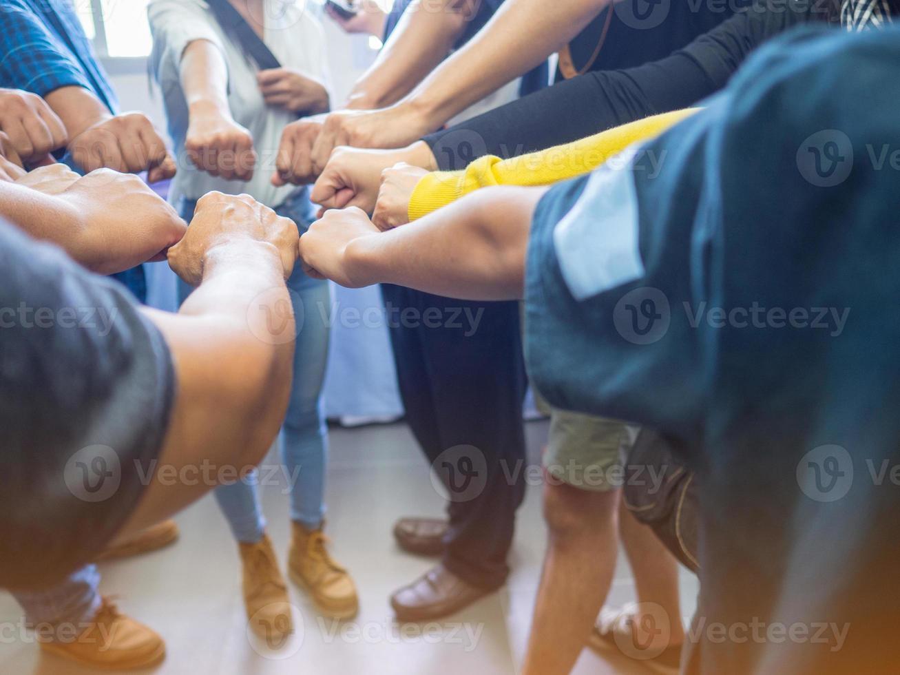 gros plan de nombreuses personnes mettant leurs poings ensemble comme symbole d'unité photo