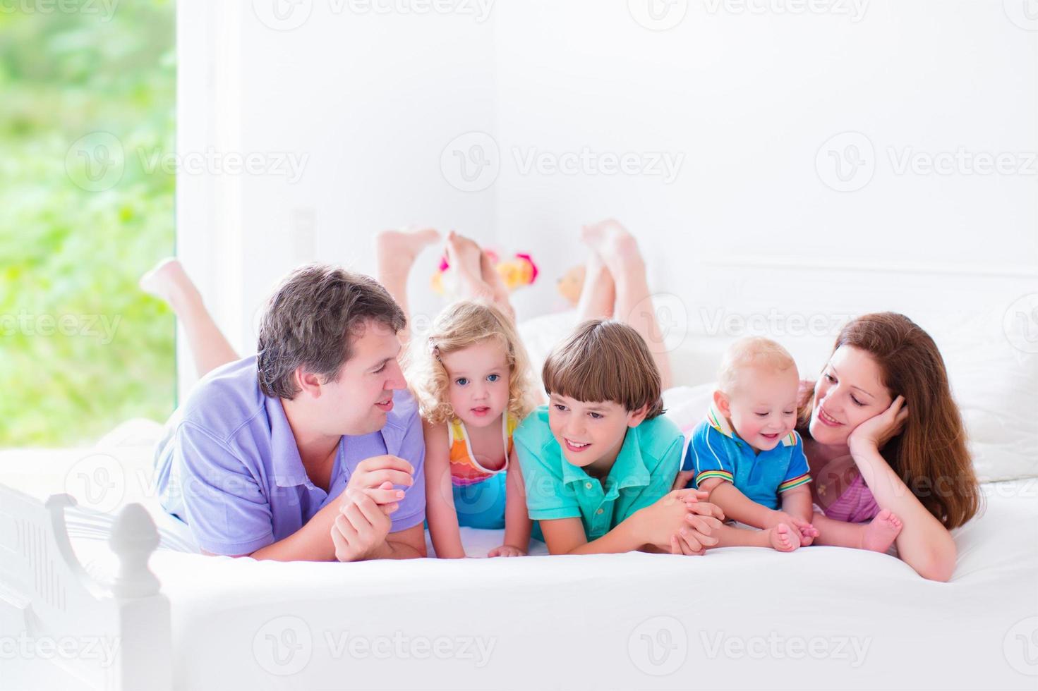 grande famille heureuse grande dans un lit photo