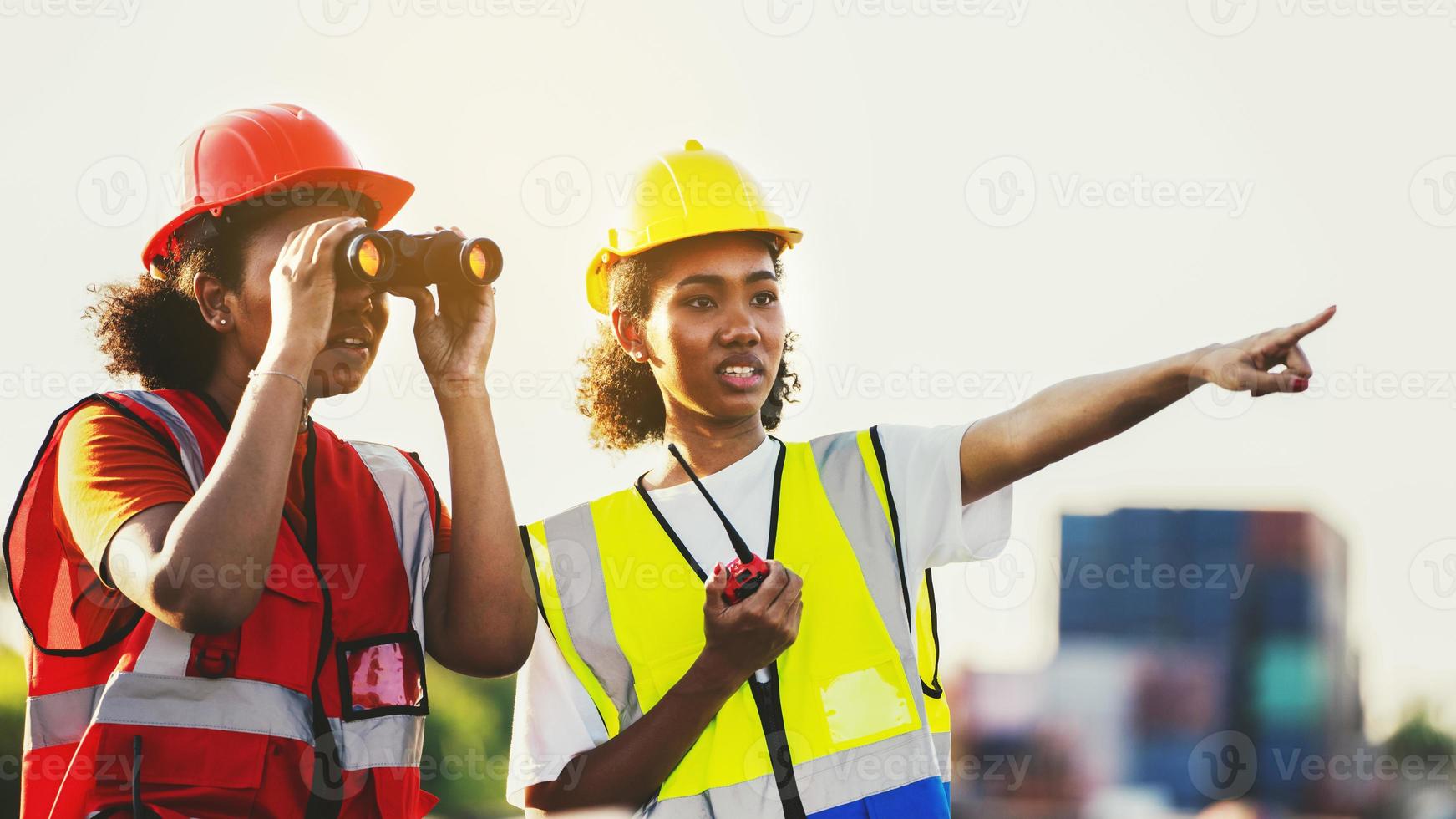 femme contremaître ou ingénieur à l'aide de jumelles et partenaire pointant vers le problème focus conteneur de fret à l'entrepôt transport logistique de conteneurs photo