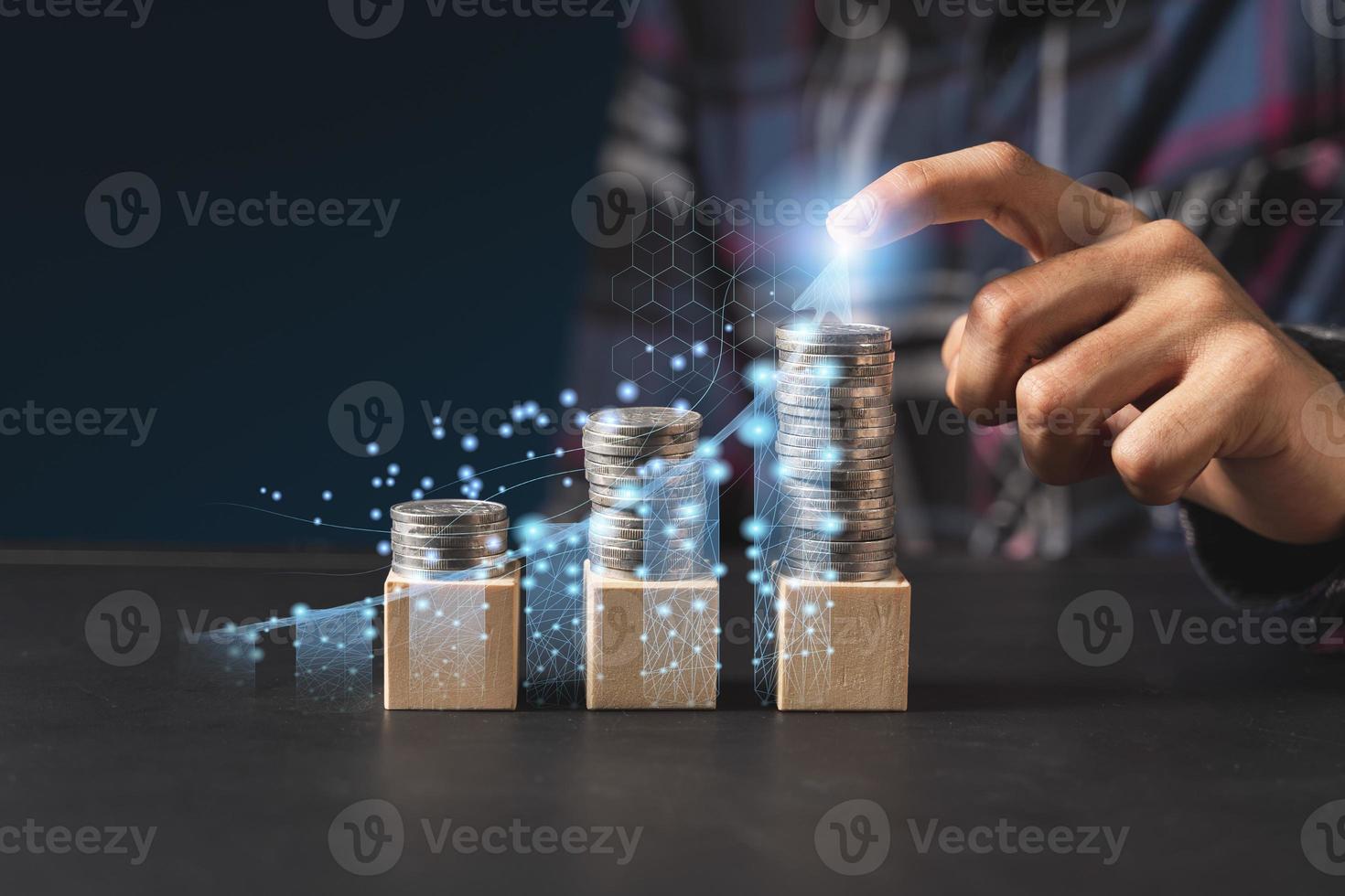 l'homme d'affaires touche un stock d'hologrammes virtuels croissant et des rangées de pièces de monnaie, une analyse des stocks d'entreprise. photo