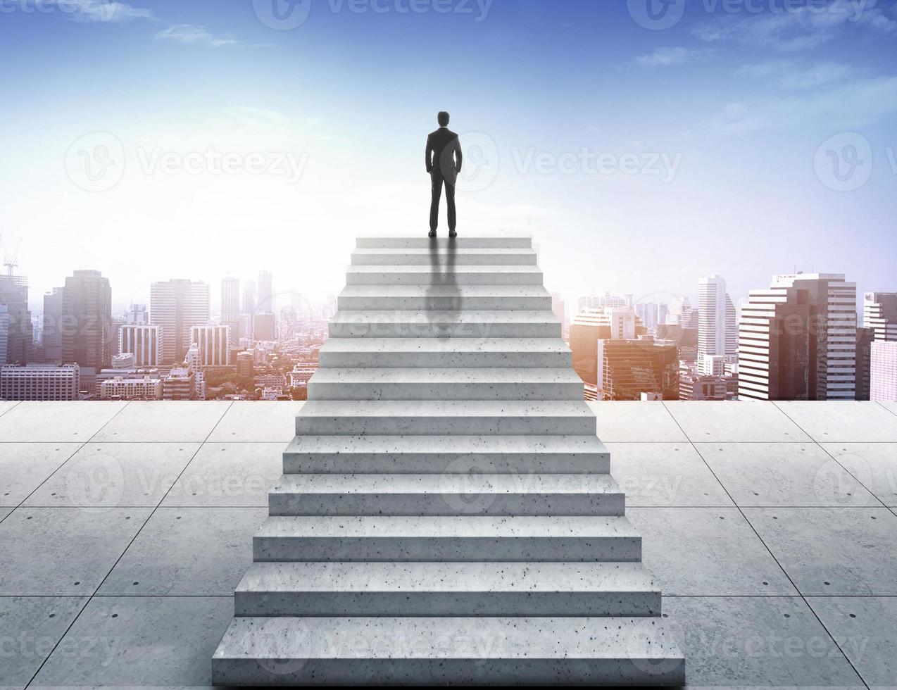 notion de vision. homme d'affaires prospère debout sur l'escalier et regardant au-dessus de la ville photo