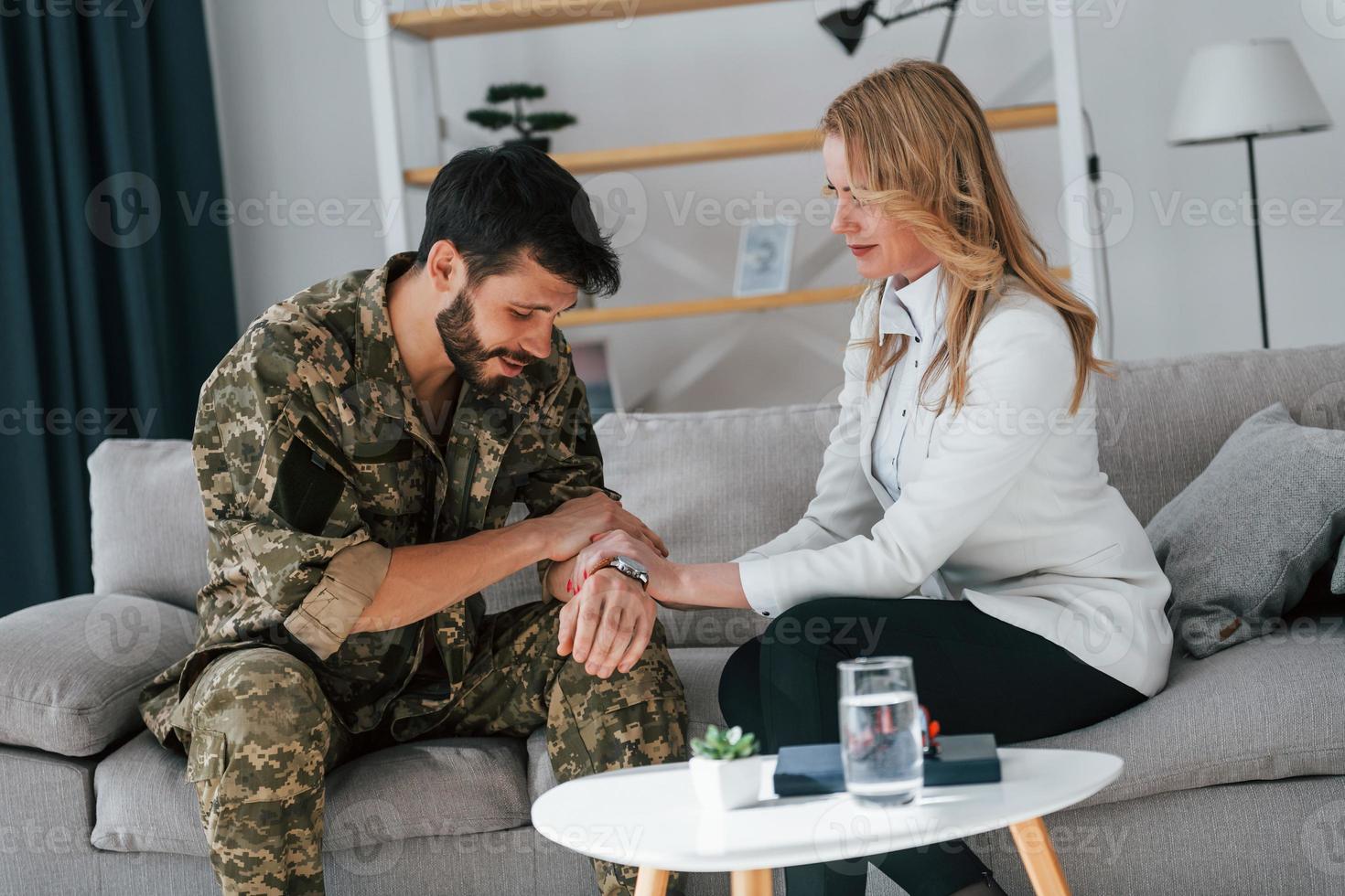 assis près de la table. un soldat a une séance de thérapie avec un psychologue à l'intérieur photo