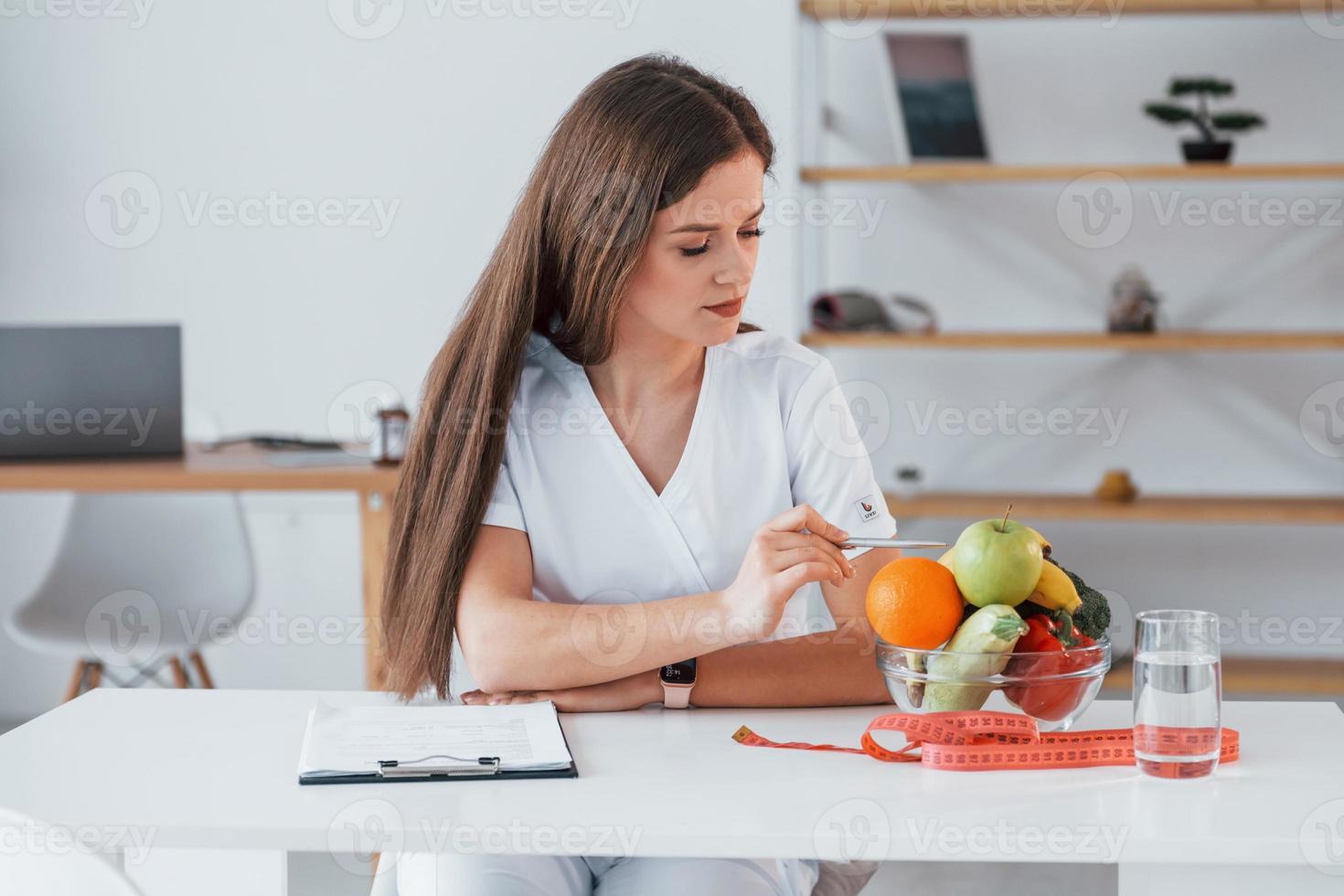 beaucoup de fruits. travailleur médical professionnel en blouse blanche est au bureau photo